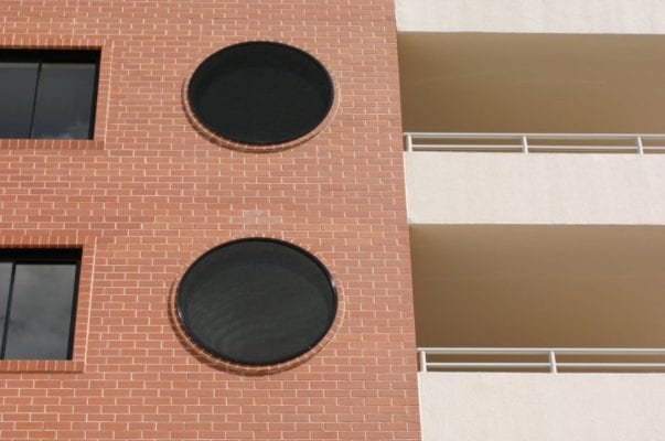A building with windows and circles on the side of it.