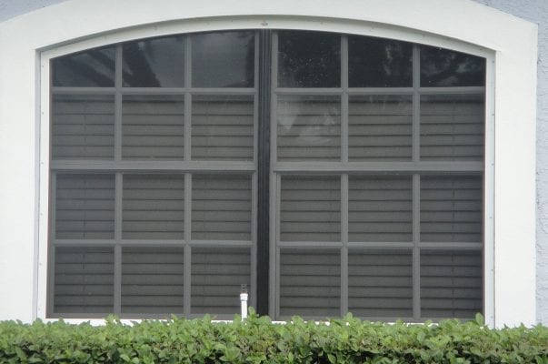 A large window with shutters on the outside of it.