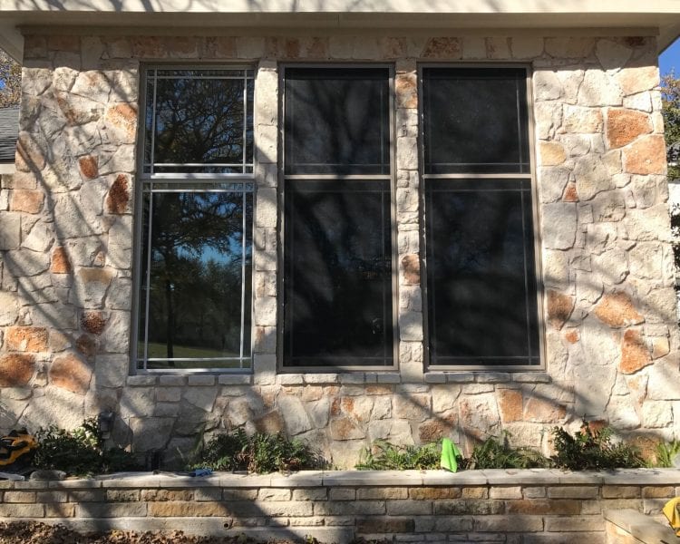 A window with three windows and two trees