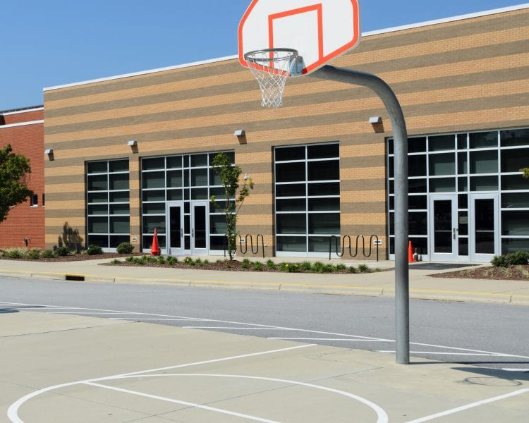 A basketball hoop in the middle of an empty court.